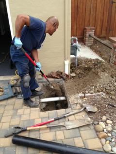 Plumbing contractor removes tiles to access a drain line